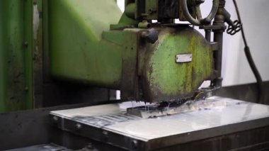 Bir fabrikanın çelik küf parçasını pürüzsüz hale getiren öğütme makinesinin yakın çekimi. Hassas mühendislik, endüstriyel imalat işi ve üretim finansmanı kavramı.