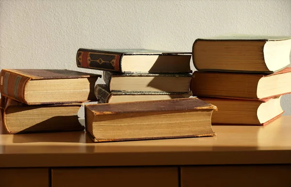 Various old hardcover science books stacked on a wooden furniture in library store