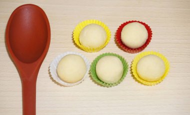 Renkli kağıt bardaklarda kurabiye pişirmeye hazır hamur topları.