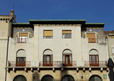 Üzerinde renkli modern dekoratif detaylar olan eski binanın taş cephesi.