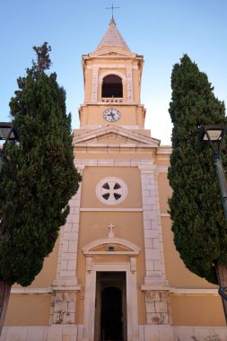 Hırvatistan 'ın Novalja kasabasında iki büyük ağaç yan yana duran Aziz Catherine Kilisesi' nin cephesi ve girişi