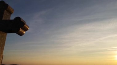 Kış günbatımının arka planında büyük bir haç