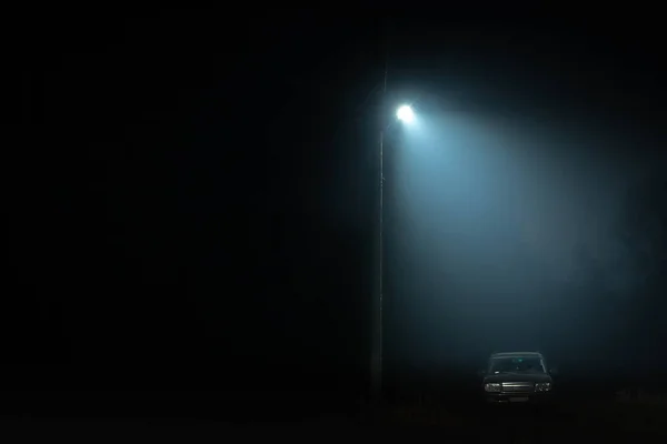 SUV at night under a street lamp