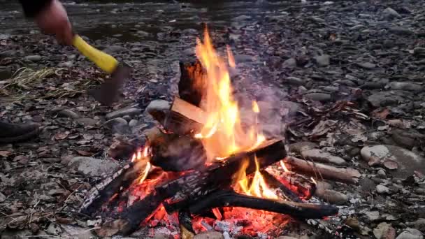 Mann Unterstützt Das Nächtliche Lagerfeuer — Stockvideo