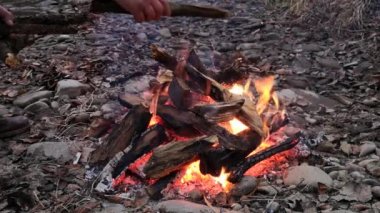 Adam gece ateşini destekliyor.