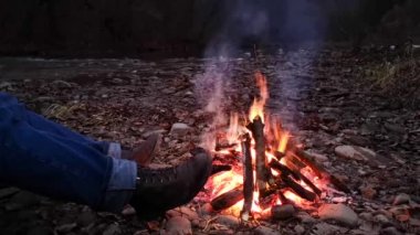 Gece ateşinde dinlenen bir adam