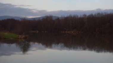 Bir dağ gölü üzerinde kış günbatımı manzarası
