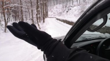 Kar yağışı altındaki bir dağ ormanında SUV