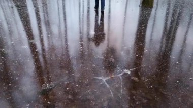 Donmuş orman gölündeki bir adamın yansıması.