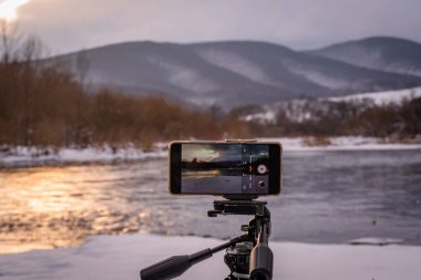 Kışın bir dağ nehrinde akıllı telefon manzarası alıyorum.