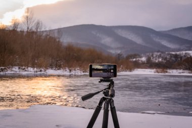 Kışın bir dağ nehrinde akıllı telefon manzarası alıyorum.