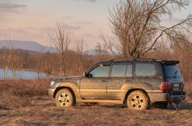 Güzel bir gün batımında bir dağ gölünün yanında SUV.