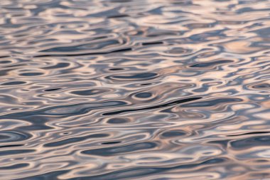 Güneşli bir dağ nehrinin desenli dalgaları