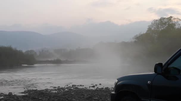 春雾蒙蒙的黄昏 与越野车在一条山河上消磨时光 — 图库视频影像