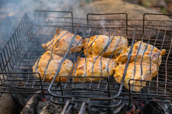 Cooking chicken over a fire in a mountain forest