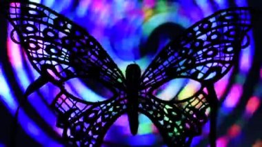 Hareket eden çok renkli bir arkaplanda açık maske kelebeği