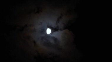 Bulutlu gece gökyüzünde ayın güçlü halesi