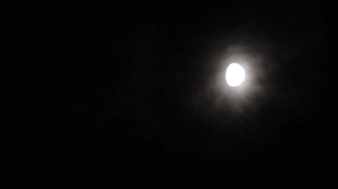 Bulutlu gece gökyüzünde ayın güçlü halesi