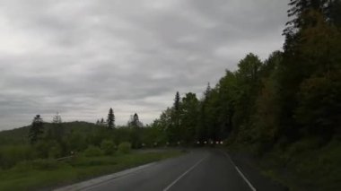 Bir off-road yolcusu Karpatlar 'da yağmurlu bir günde karayoluyla seyahat eder.
