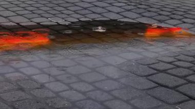 Yağmur sırasında su birikintisindeki aydınlanmanın yansıması