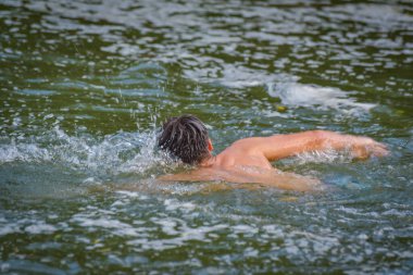 Adam bir dağ nehrinde sürünüyor.