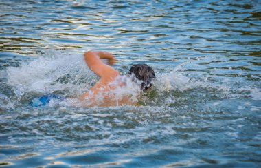 Adam bir dağ nehrinde sürünüyor.