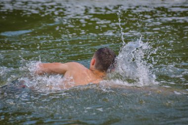 Adam bir dağ nehrinde sürünüyor.