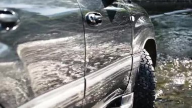 SUV bir dağ nehri üzerinde seyahat eder.