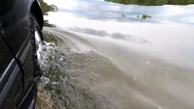SUV bir dağ nehri üzerinde seyahat eder.