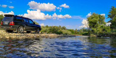 Yazın bir dağ nehrinde SUV