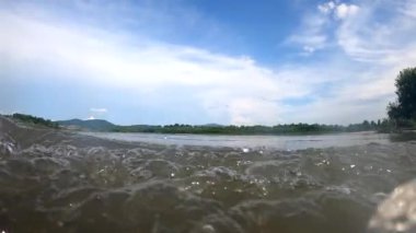 Bir yaz akşamı akan bir dağ nehrinin manzarası.