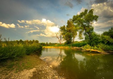 Bir yaz akşamı akan bir dağ nehrinin manzarası.