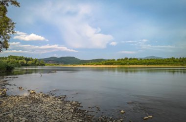 Bir yaz akşamı akan bir dağ nehrinin manzarası.
