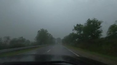 Kasırganın ortasında şiddetli bir yağmurda bir SUV otobanda sürüyor.