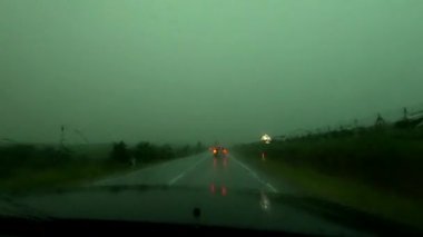 Kasırganın ortasında şiddetli bir yağmurda bir SUV otobanda sürüyor.