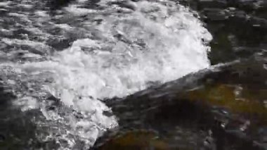 Hızlı bir dağ nehrinin doğal güneşli bokeh 'i