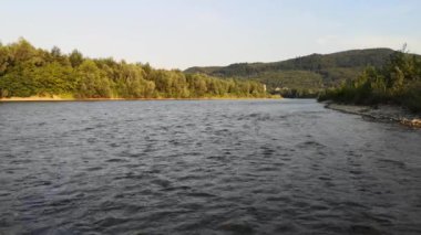 Bir yaz akşamı akan bir dağ nehrinin manzarası.