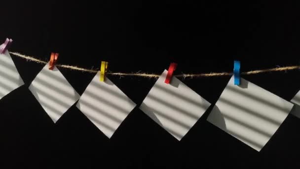 Pezzi Carta Bianchi Con Ombre Strisce Svolazzano Sulla Clothesline — Video Stock