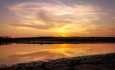 Gün batımında bir yaz gölünün akşam manzarası
