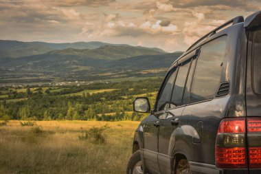 SUV yazın dağlık bir alanda seyahat ediyor.