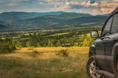SUV yazın dağlık bir alanda seyahat ediyor.