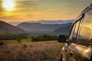 SUV yazın dağlık bir alanda seyahat ediyor.