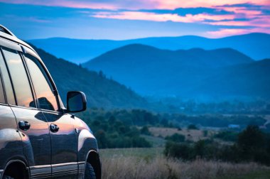 SUV yazın dağlık bir alanda seyahat ediyor.