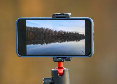 Akıllı telefon bir kış gölü manzarasının videosunu çeker.