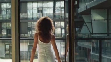Genç ve güzel bir kadın dairesinin balkonuna çıkıyor. O, havanın tadını çıkarıyor. 4K