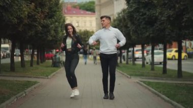 Bir adam ve bir kadın şehirde dolaşıyorlar. Gülümsüyorlar ve zıplıyorlar. 4K