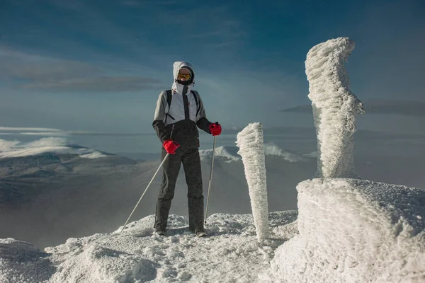 Genç bir kadın karlı bir dağın tepesinde yürüyor. Onun yanında büyük kar yığınları var. Pikui Dağı.