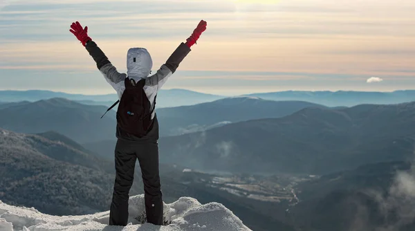 Genç bir kadın karla kaplı bir dağın kenarında duruyor. Bu dağı fethettiği için sevinçle ellerini kaldırıyor. O, manzaraya bakıyor. Pikui Dağı.