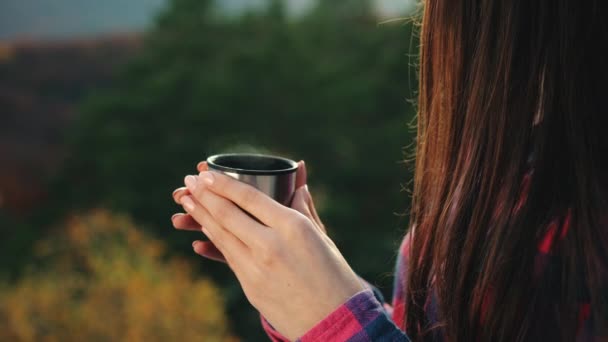 Mladá žena drží šálek horkého čaje. Sedí na skále. Turistika v horách. 4K — Stock video
