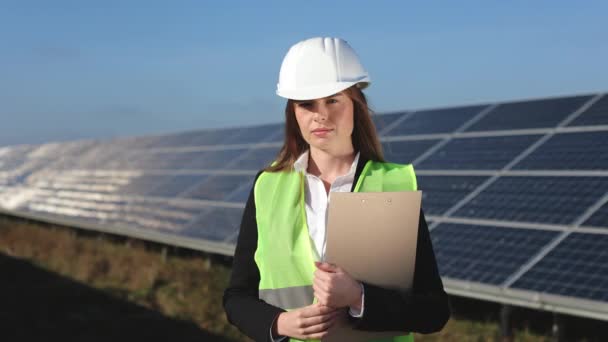 A young female engineer is looking at the camera. Shes holding a folder of documents. 4K — Stock Video